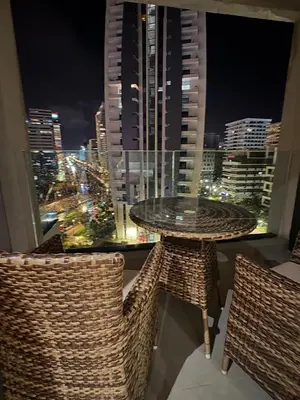 a table and chairs on a balcony with a view of a city at Appartement haut standing Casablanca in Casablanca