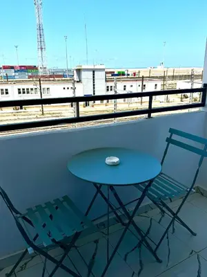 a table and two chairs on a balcony with a view of a train at Pause cosy moderne in Casablanca