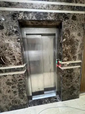 a metal elevator in a room with a stone wall at Pause cosy moderne in Casablanca