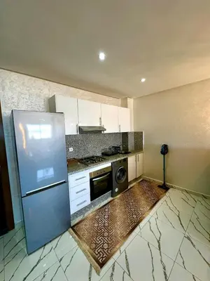 a kitchen with a stainless steel refrigerator and a microwave at Pause cosy moderne in Casablanca