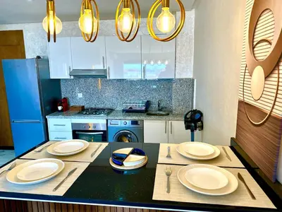 a kitchen with a table with plates on it at Pause cosy moderne in Casablanca