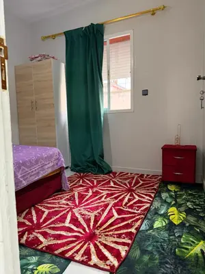 a bedroom with a bed and a rug on the floor at Résidence Haja in Casablanca