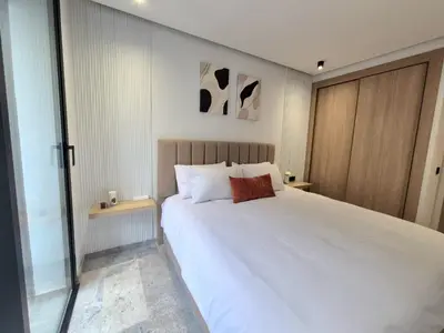 a bedroom with a large white bed and two tables at VIVASTAY Casablanca - Metropole Bd Abdelmoumen in Casablanca