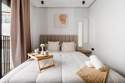 a bedroom with a large bed with a wooden table at VIVASTAY Casablanca - Metropole Bd Abdelmoumen in Casablanca