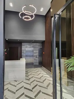 an office lobby with a glass door and a chandelier at VIVASTAY Casablanca - Metropole Bd Abdelmoumen in Casablanca