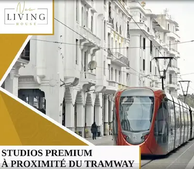 a red tram on a city street next to buildings at Studio Signature - Parking privé & neuf in Casablanca