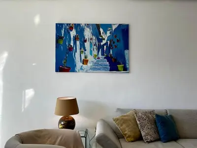 a living room with a couch and a painting on the wall at Luxurious 1BR Orangeraie - Terrace & Pool in Oulad Akkou