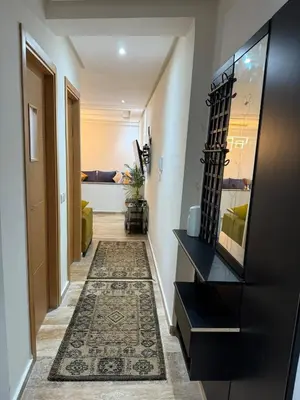 a hallway with a black dresser and a rug at Appartement spacieux Océan Rabat in Rabat