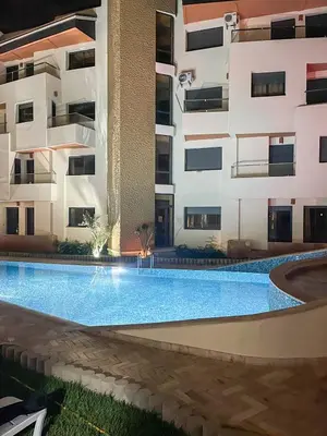 an empty swimming pool in front of a building at Appartement bord de mer avec piscine à Bouznika in Bouznika