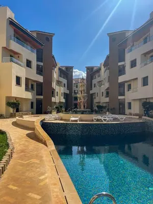 a swimming pool in front of some apartment buildings at Appartement bord de mer avec piscine à Bouznika in Bouznika
