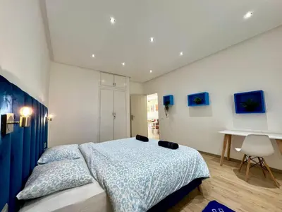a bedroom with a bed and a desk in it at Cozy & Stylish 2BR - Near Arribat Center Mall in Rabat