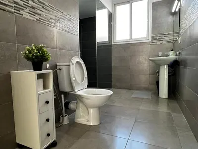 a bathroom with a toilet and a sink at Cozy & Stylish 2BR - Near Arribat Center Mall in Rabat