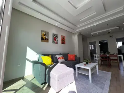 a living room with a couch and a table at Cozy & Stylish 2BR - Near Arribat Center Mall in Rabat