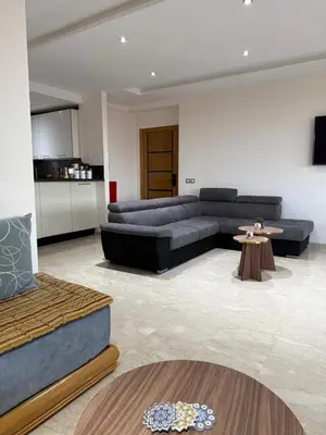 a living room with a couch and a table at Evasion apartment with beach and pool views in Bouznika