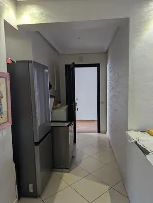 a hallway with a refrigerator and a door to a room at Maison Lalla najat in Sidi Rahal