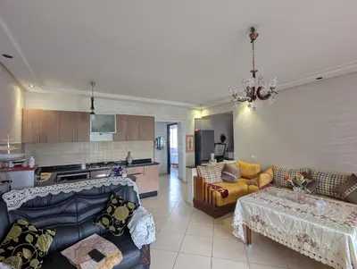 a living room with couches and a kitchen at Maison Lalla najat in Sidi Rahal