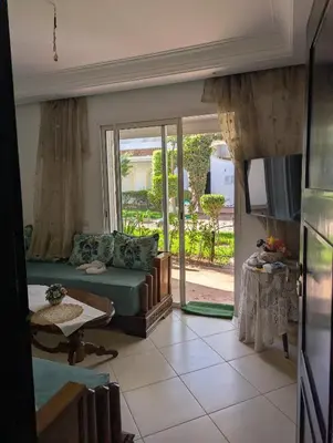 a living room with a couch and a sliding glass door at Maison Lalla najat in Sidi Rahal