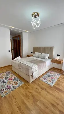 a bedroom with a large bed and two rugs at Anfa Ivory Hassan II in Casablanca