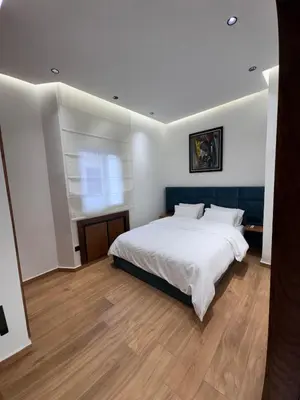 a bedroom with a large white bed and a window at Luxury apartment in Rabat