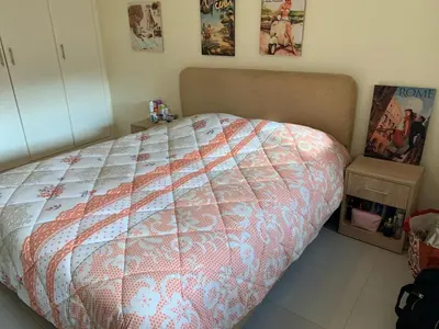 a bedroom with a bed with a comforter on it at AFCON near rabat complex de football in Bouznika