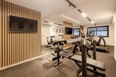a gym with several tread machines and a flat screen tv at Loft - Literie Premium, Fibre optique, IPTV, GYM, Terrasse in Casablanca