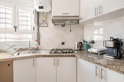 a white kitchen with a sink and a stove at Agdal Train Station Modern&Stylish Apartments in Rabat