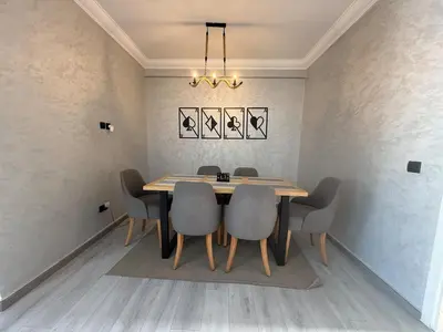 a dining room with a wooden table and chairs at Lumineux cosy appartement - océan Rabat in Rabat