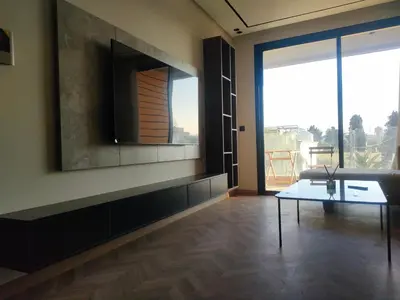 a living room with a table and a large window at Studio neuf - haut standing in Casablanca