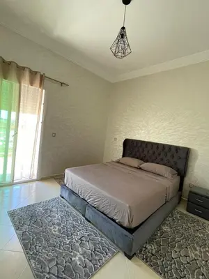 a bedroom with a bed and a rug at Saad in Mohammedia