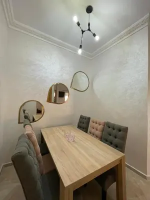 a dining room with a wooden table and mirrors at Saad in Mohammedia