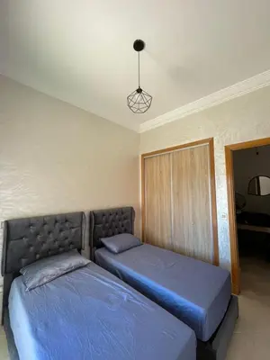 a bedroom with two beds and a chandelier at Saad in Mohammedia