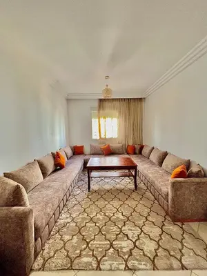 a living room with a large couch and a coffee table at Zenata Family Apartment in Aïn Harrouda