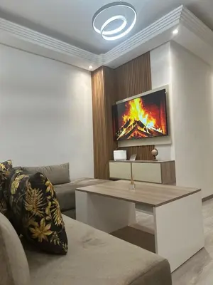 a living room with a couch and a tv on a wall at Confort et mer Océan Rabat in Rabat