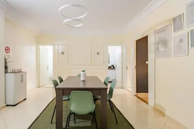 a dining room with a table and green chairs at Authentic & Spacious 2 Bedrooms Heart of Rabat in Rabat