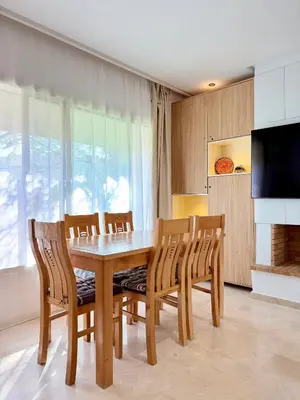 a dining room with a wooden table and chairs at Charmante maison de vacances proche de la plage à quelques minutes de Rabat in Temara