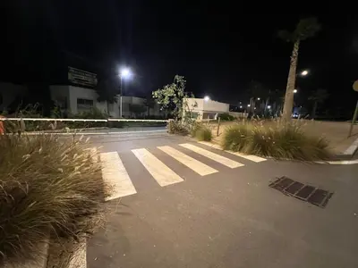 an empty parking lot at night with a palm tree at Charmante maison de vacances proche de la plage à quelques minutes de Rabat in Temara