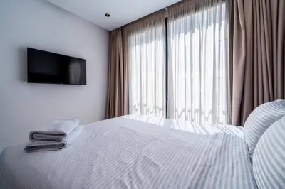 a bedroom with a bed with a television on the wall at Appartement Design avec Parking et Salle de Sport Ferme Bretonne in Casablanca
