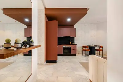 a living room with a kitchen and a dining room at Appartement Design avec Parking et Salle de Sport Ferme Bretonne in Casablanca