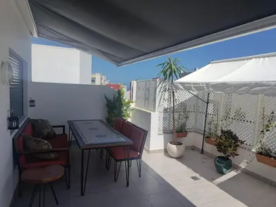 a balcony with a table and chairs and an umbrella at 2 min walk from Four Seasons Hotel-Cozy Terrace Stay in the Heart of Rabat in Rabat