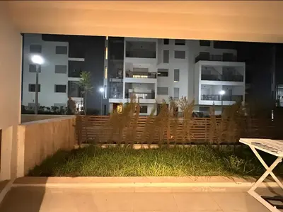 a backyard with a wooden fence and grass at RDJ 2CH haut standing - Bouskoura in Bouskoura