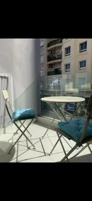 two chairs and a table in a room with a building at Studio lumineux et cosy in Casablanca