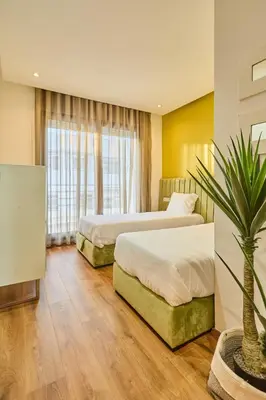 a hotel room with two beds and a potted plant at Terrasses and Sunset Duplex Luxe 3 Bed in Ghandi in Casablanca
