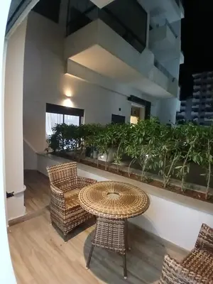 a patio with a table and chairs and plants at Studio Cosy avec Piscine & proche de la plage in Aïn Harrouda