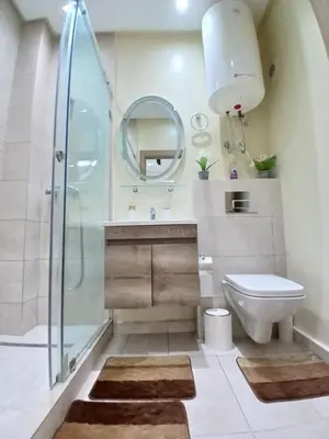 a bathroom with a shower and a toilet and a sink at Studio Cosy avec Piscine & proche de la plage in Aïn Harrouda