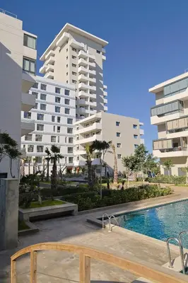 a view of two tall buildings and a swimming pool at Studio Cosy avec Piscine & proche de la plage in Aïn Harrouda