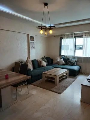 a living room with a blue couch and a table at Mohemmadia in Mohammedia