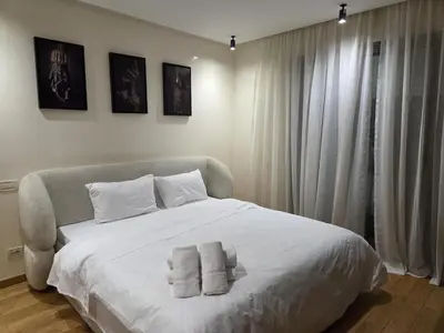 a bedroom with a white bed with towels on it at Luxury 1 bedroom at La marina in Casablanca