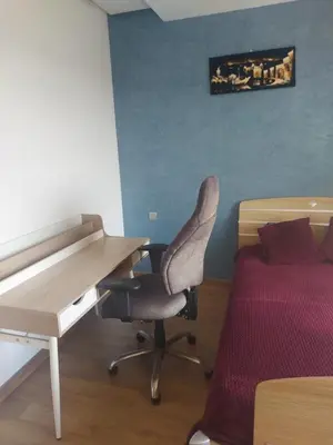 a desk and a chair in a room with a bed at Prestigia Luxurious 3BR 5 min walk from stadium in Rabat