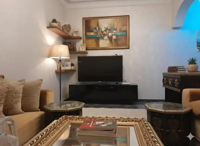 a living room with a couch and a flat screen tv at Appartement dans le centre de la plage de av Tantan in Casablanca