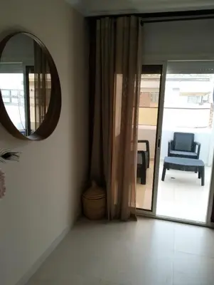 a mirror in a room with a chair and a window at Luxury Apartment Agdal, Ideal for CAN 2025 Fans in Rabat